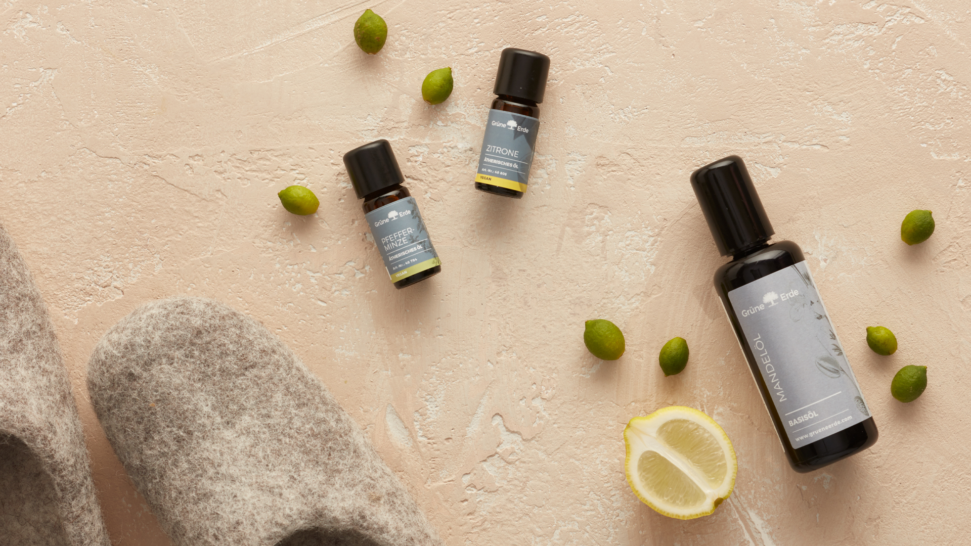 Basisöl und ätherische Öle mit Knospen und einer Zitrone dekorativ angeordnet
