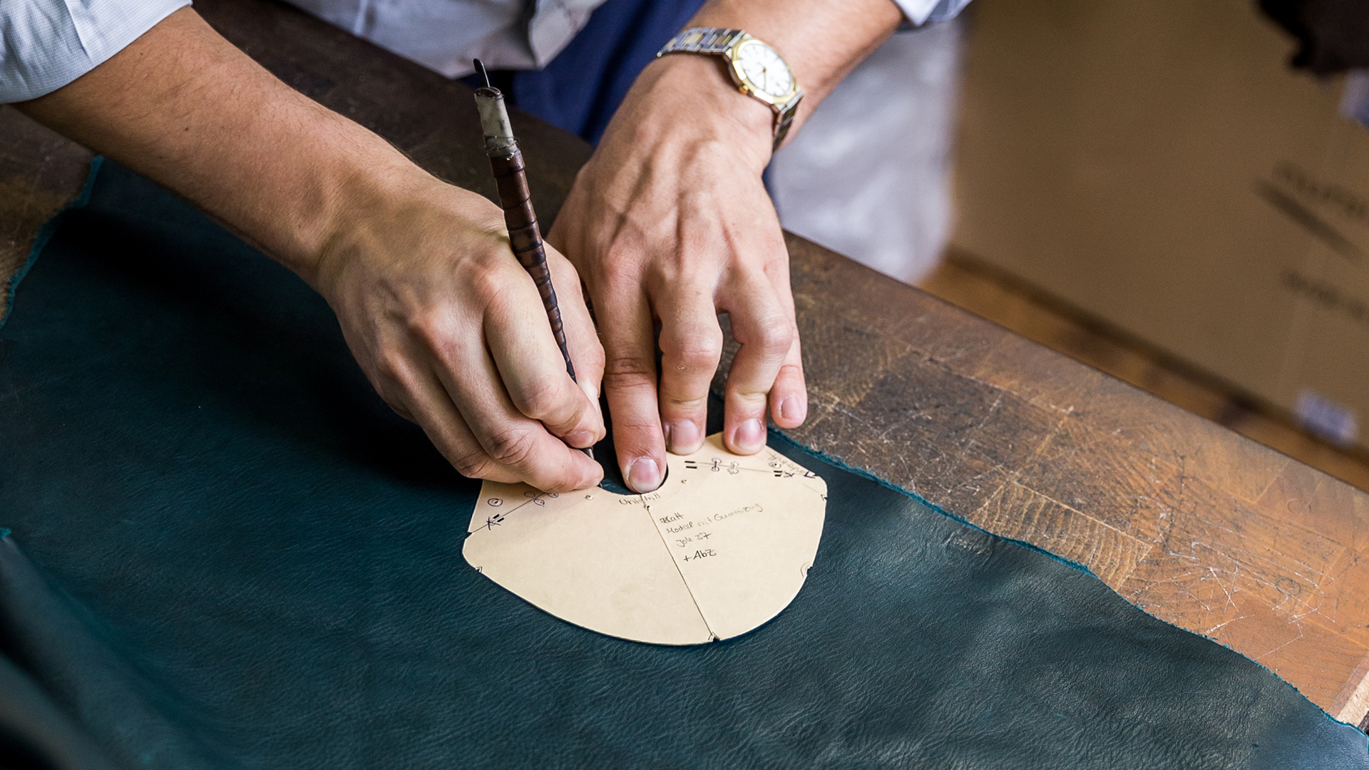 Der Schuhmacher schneidet das Leder für den Schuh zu