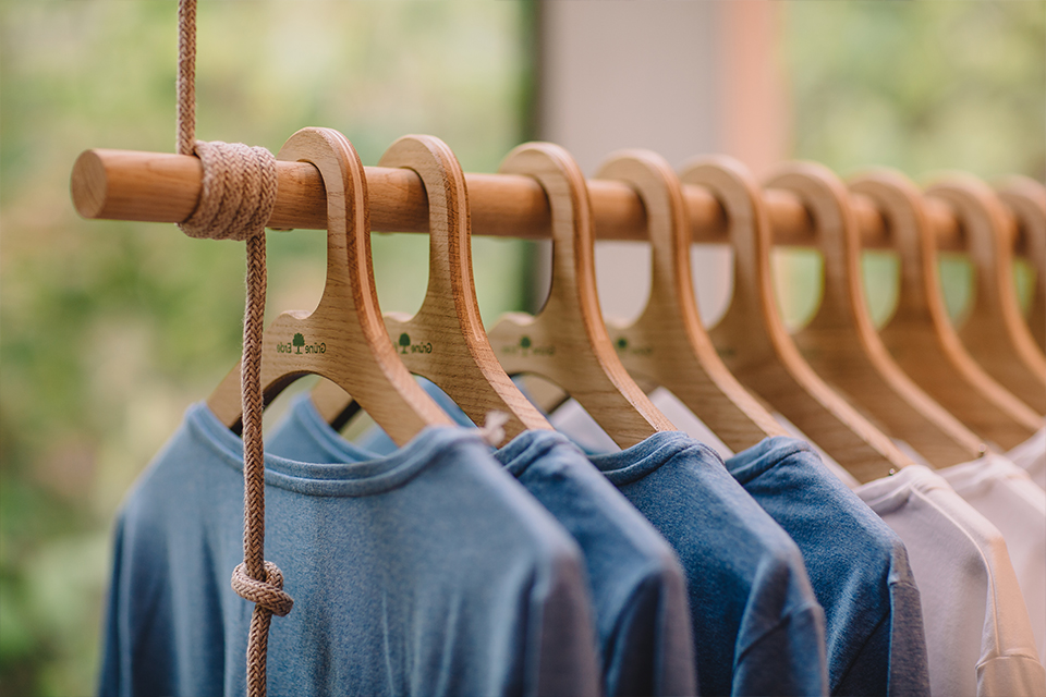 Kleiderbügel mit Kleidung ordentlich aufgehängt in Garderobe