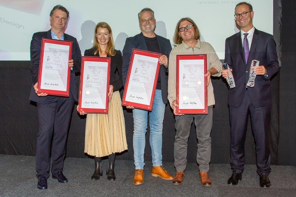 Menschen halten feierlich Urkunden bei einer Auszeichnung