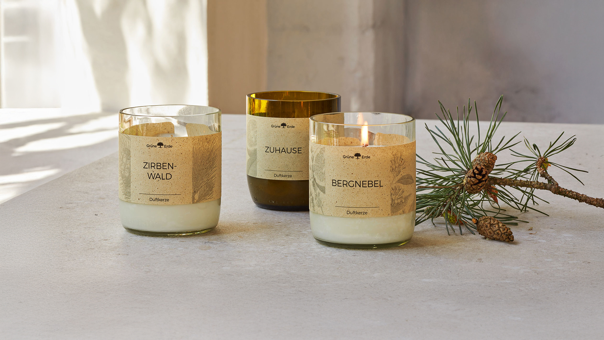 Duftkerzen auf einem Tisch stehend mit einem Tannenzweig