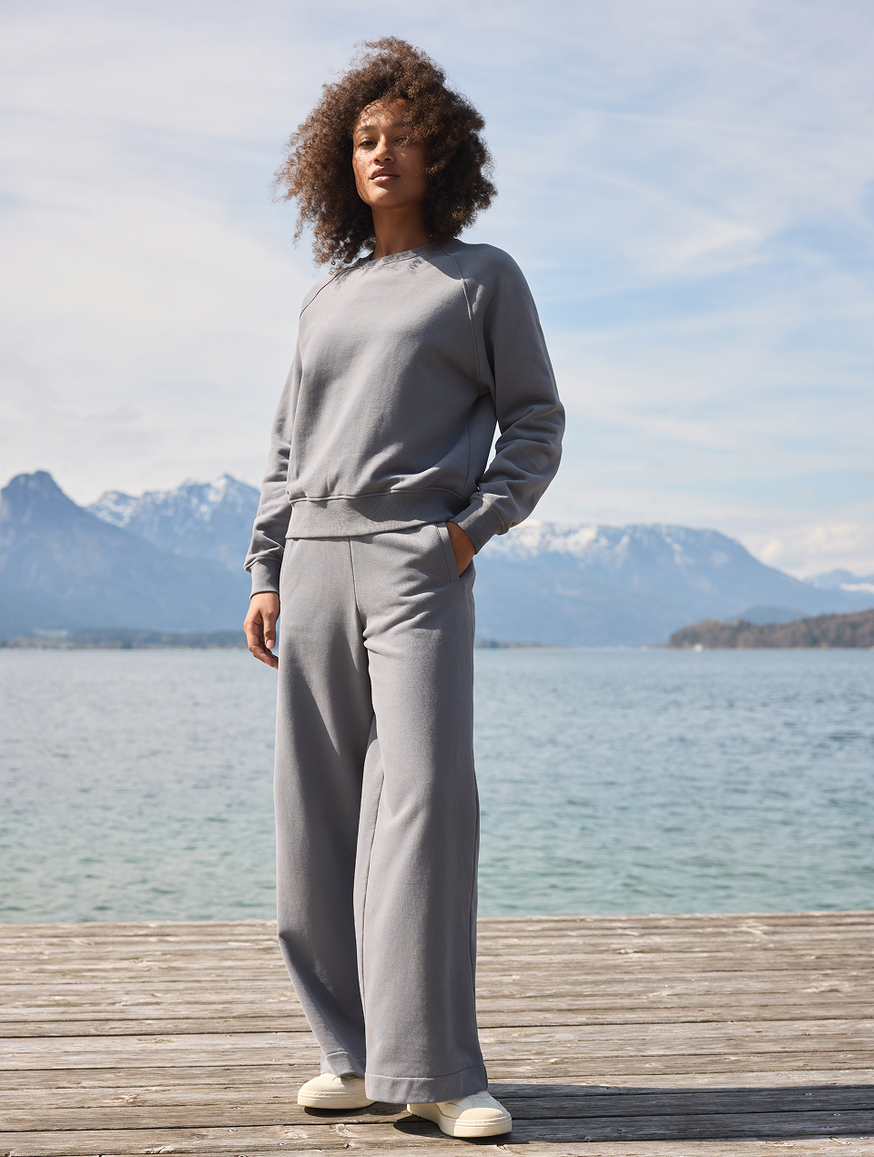 Frau steht am Steg und trägt ein dunkelblaues Loungewear-Set