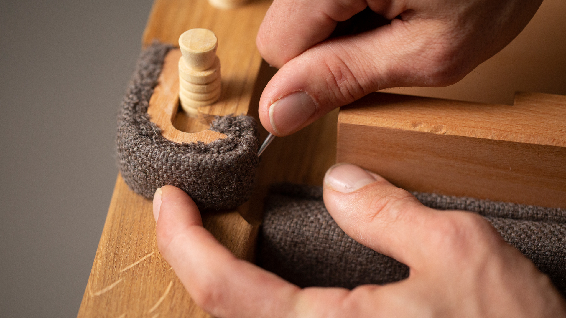 Holzmöbel wird mit Stoff bezogen bei der Fertigung