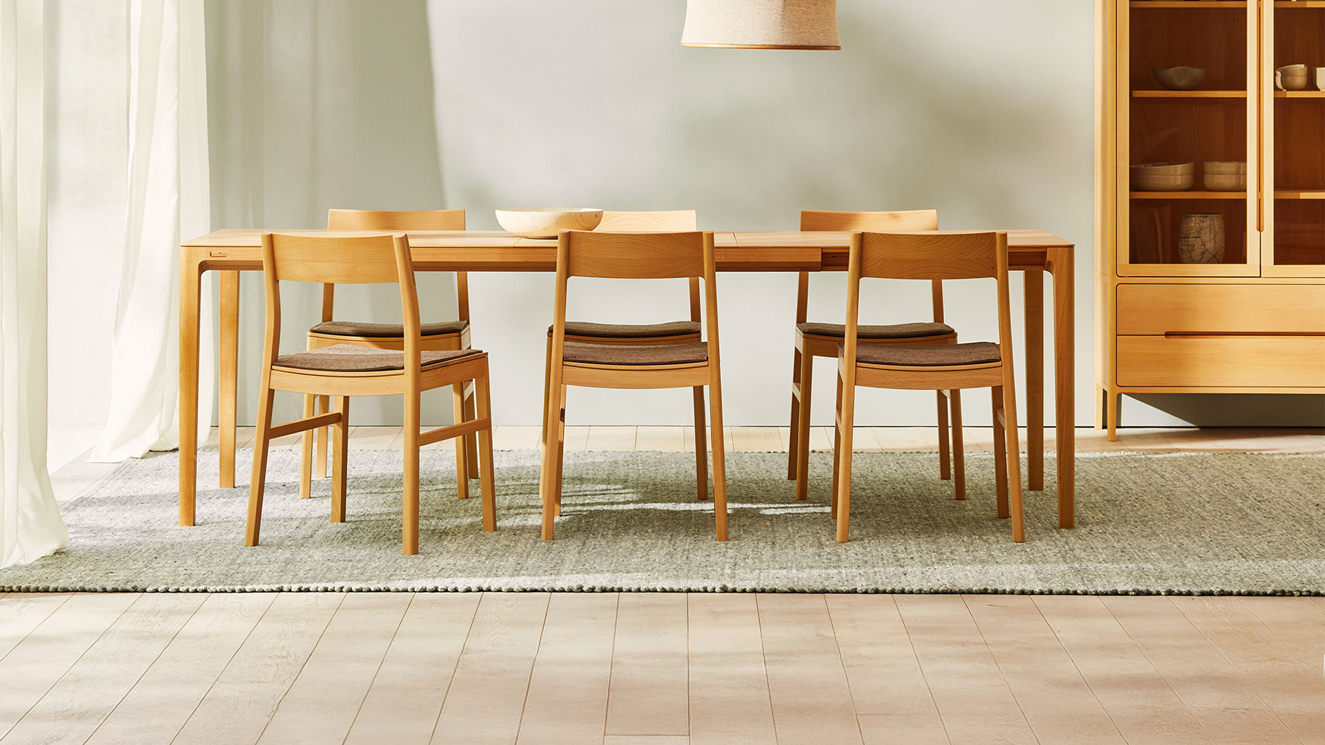 Massivholztisch mit Stühlen und Vitrine im Esszimmer