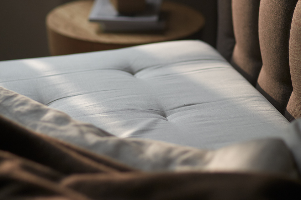 Eine Matratze liegt in einem braunen Bett