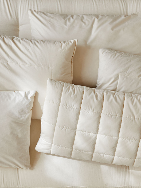 5 verschiedene Schlafkissen auf einer ökologischen Naturmatratze