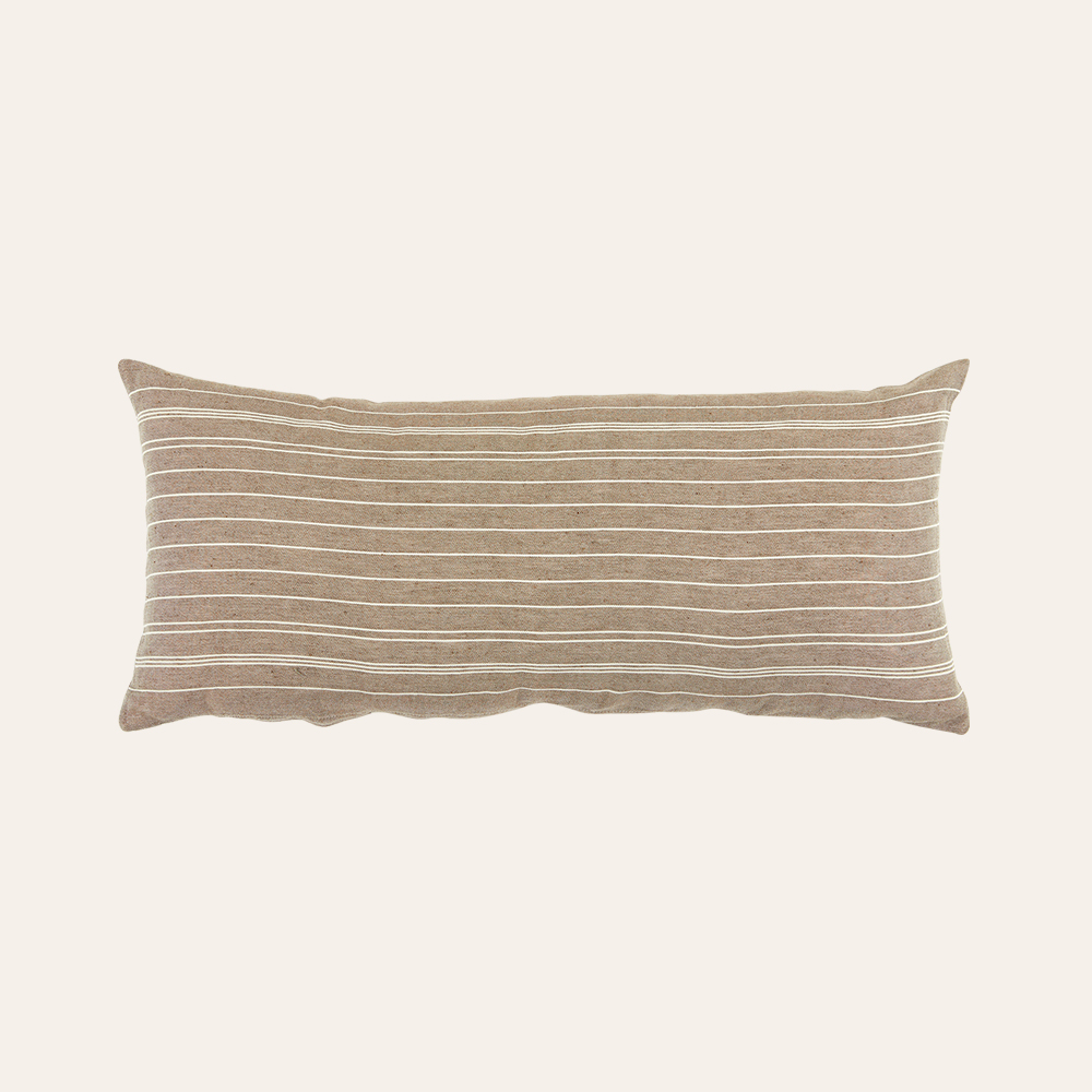 Zierkissen mit Streifenmuster auf weißem Hintergrund