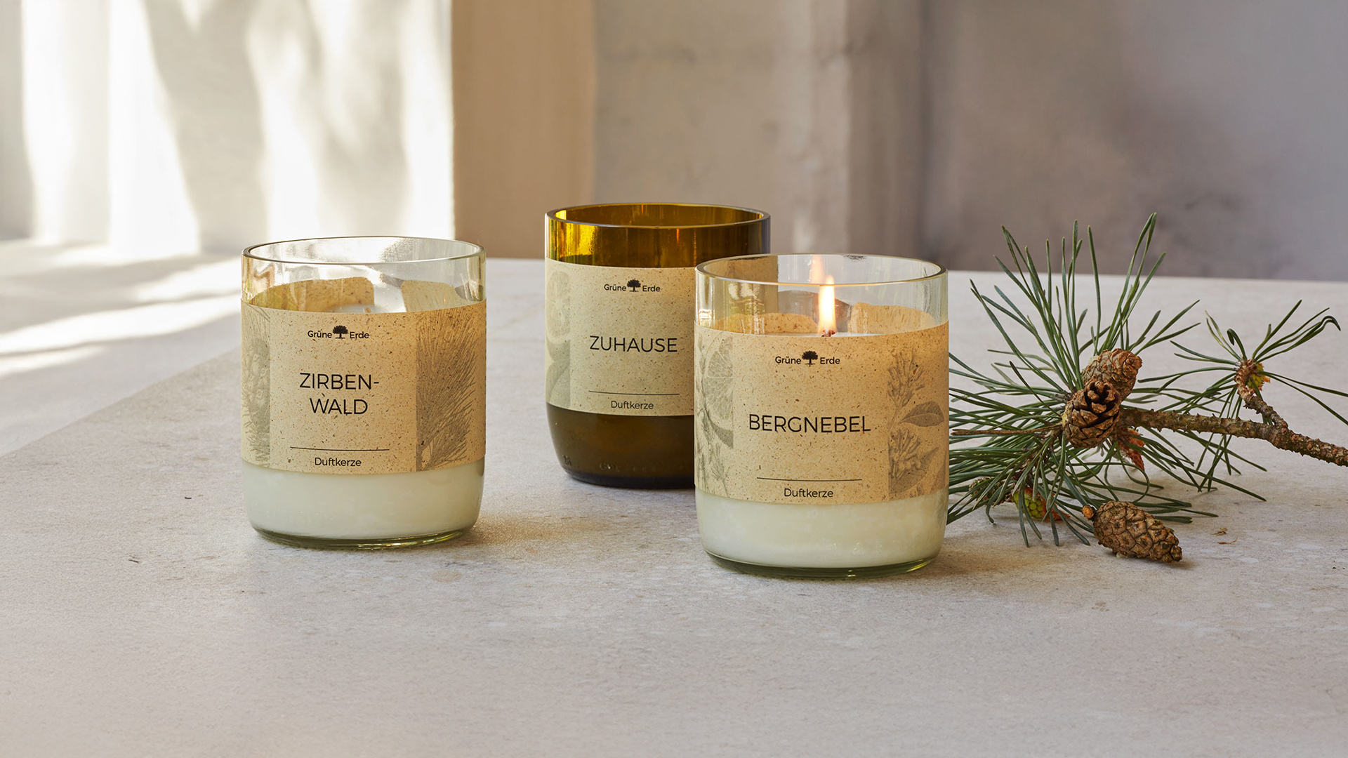 Duftkerzen auf einem Tisch stehend mit einem Tannenzweig