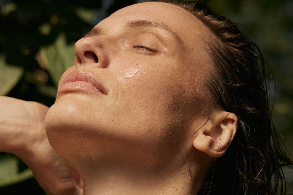 Frau streckt ihr Gesicht in die Sonne