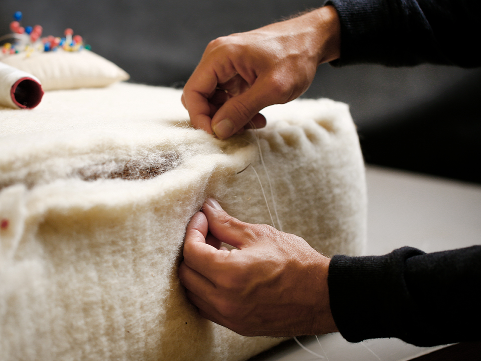 Hände beim nähen eines Sofas