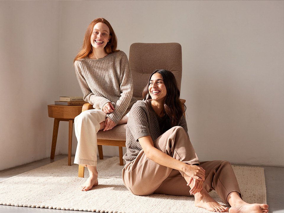 Zwei Frauen sitzen entspannt und lachen zusammen