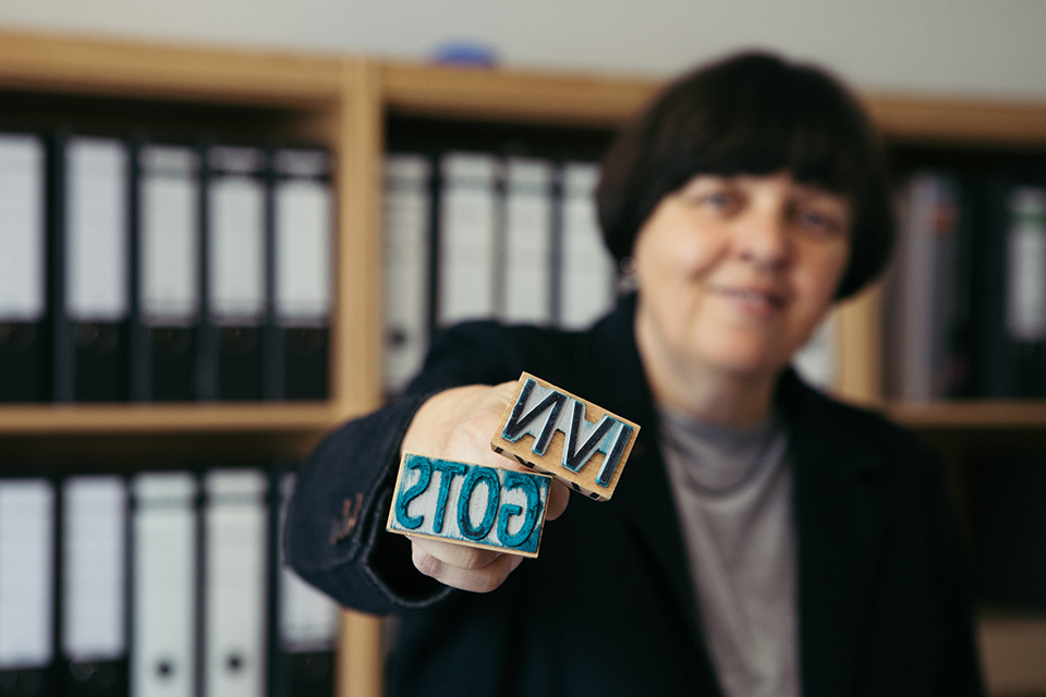 Frau hält Stempel in die Kamera