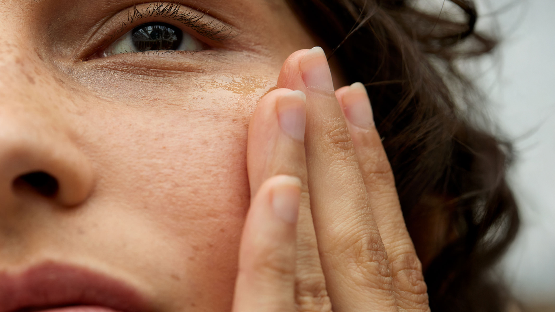 Nahaufnahme eines Gesichts mit einer Hand an der Wange