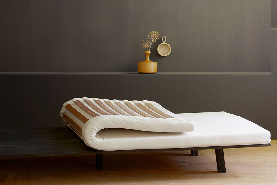 Federelement in dunklem Raum mit Vase und Deko