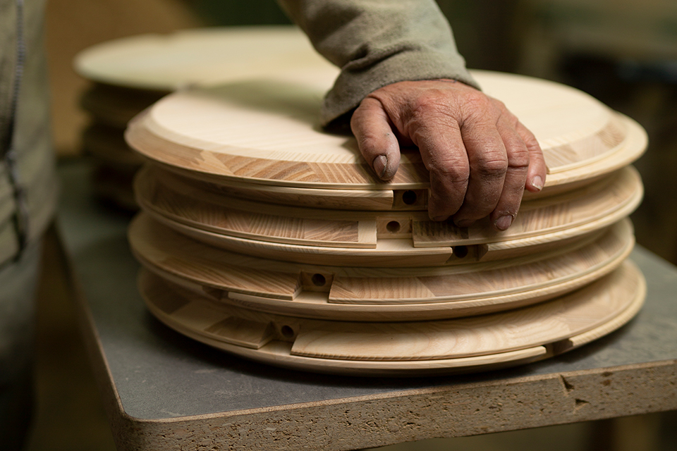 Hand liegt auf Stapel von Gegenständen aus Holz