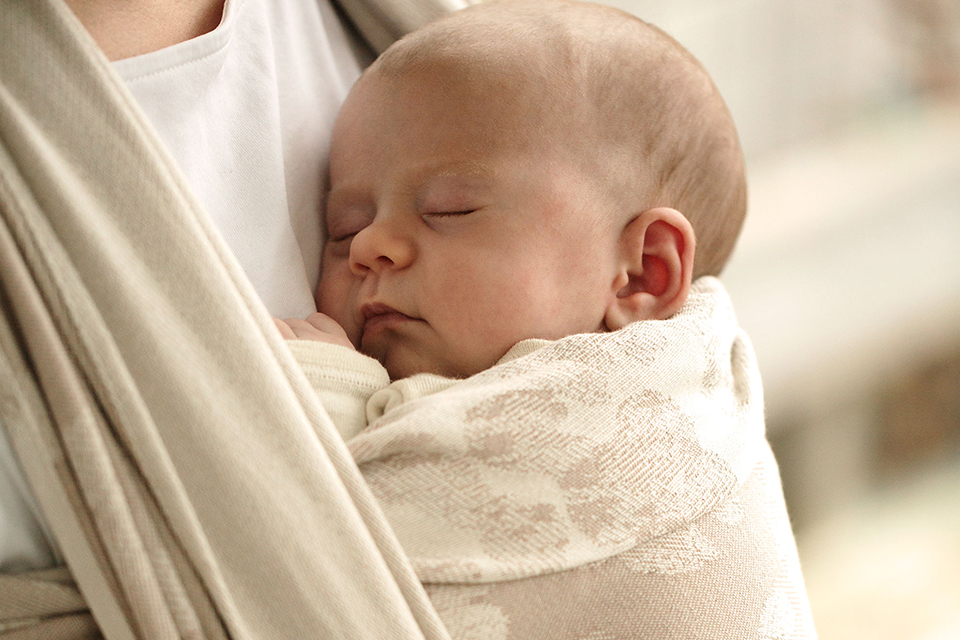 Schlafendes Baby im Tragetuch hängend
