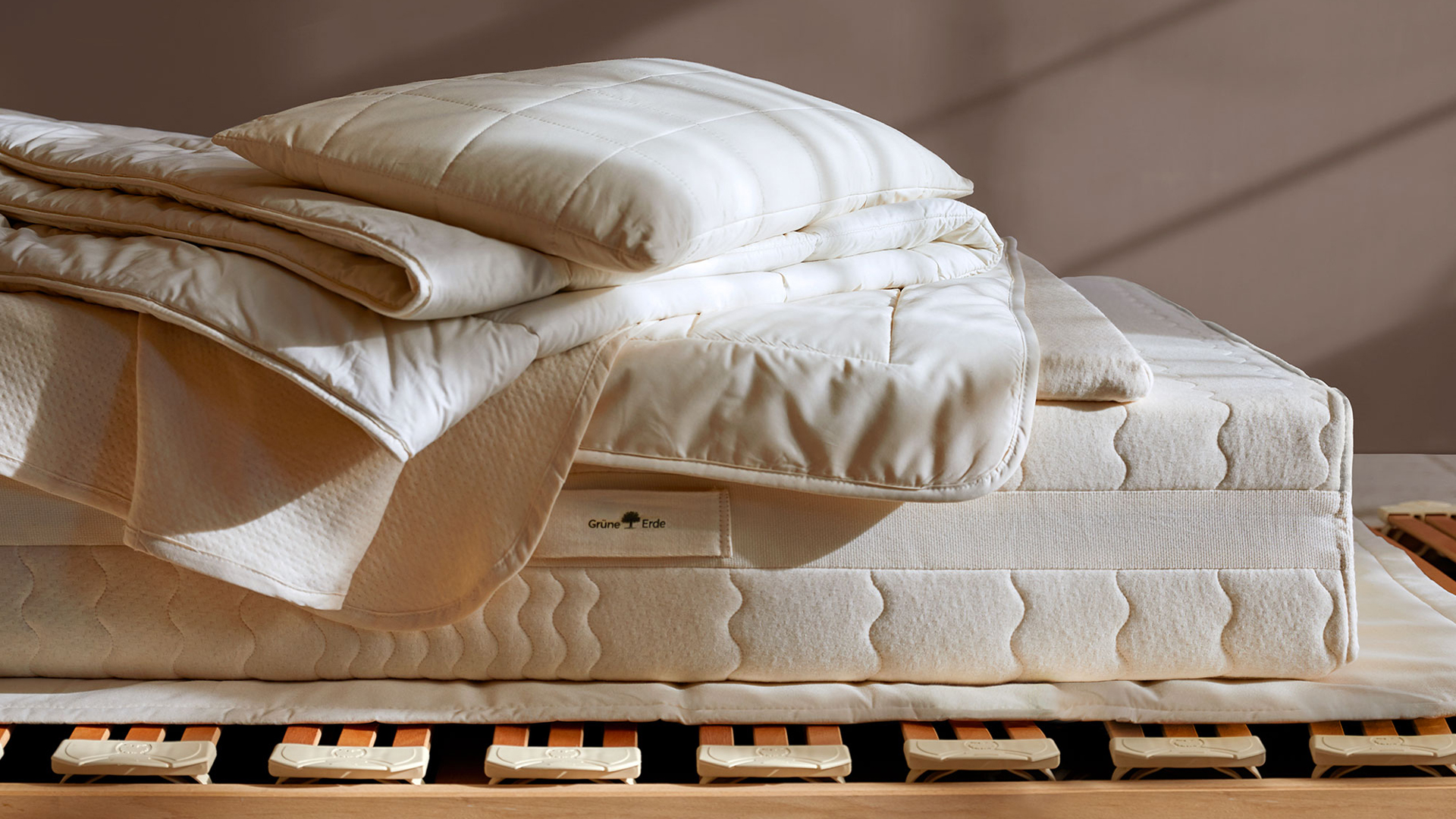 Ökologische Bettwaren liegen auf einer Naturmatratze und einem hochwertigen Lattenrost