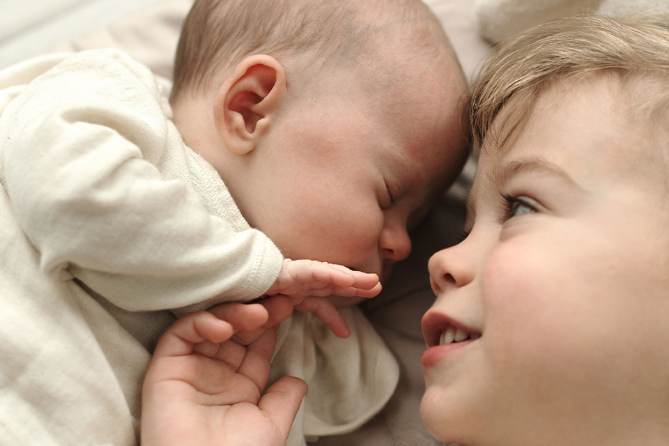Ein Baby schläft Kopf an Kopf mit seinem Geschwisterchen