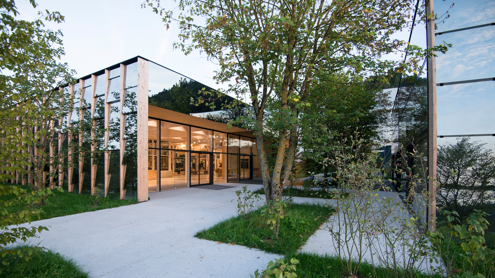 Modernes Gebäude mit Glasfassade und begrüntem Außenbereich