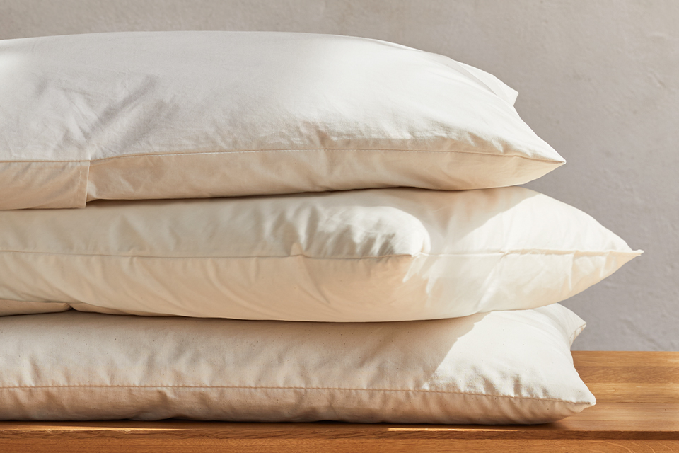 Drei hochwertige Kopfkissen auf einer Holzbank