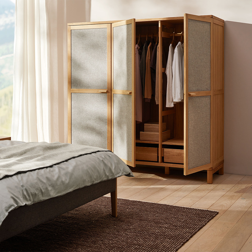 Kleiderschrank aus Massivholz mit Türfüllungen aus grauem Wollstoff