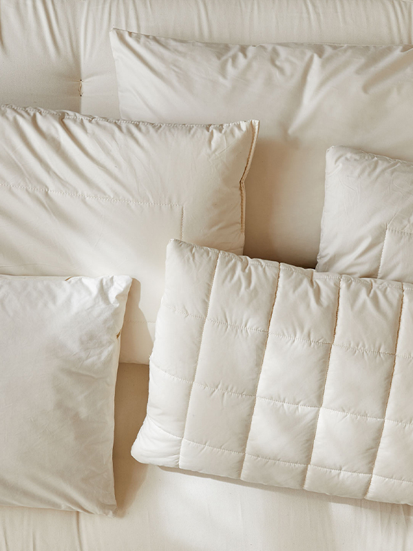 verschiedene ökologische Schlafkissen liegen auf einer Matratze