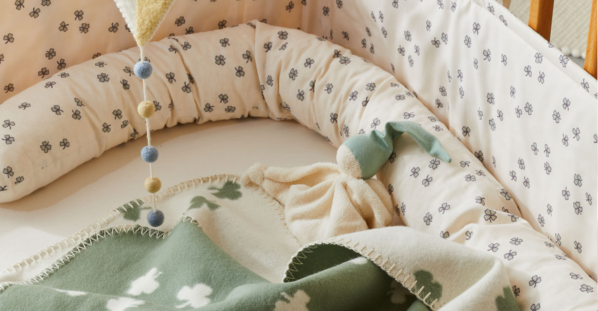 Kinderdecke mit Kleemuster und Schlafschlange mit Pünktchendesign in einem Kinderbett