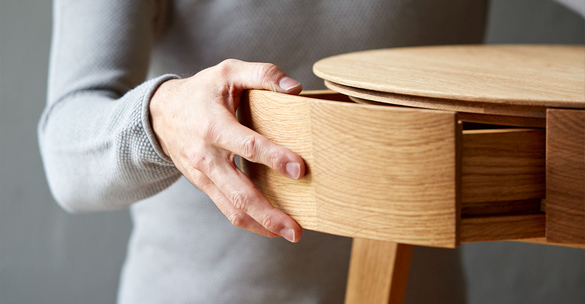 Hand öffnet die Schublade eines Beistelltisches