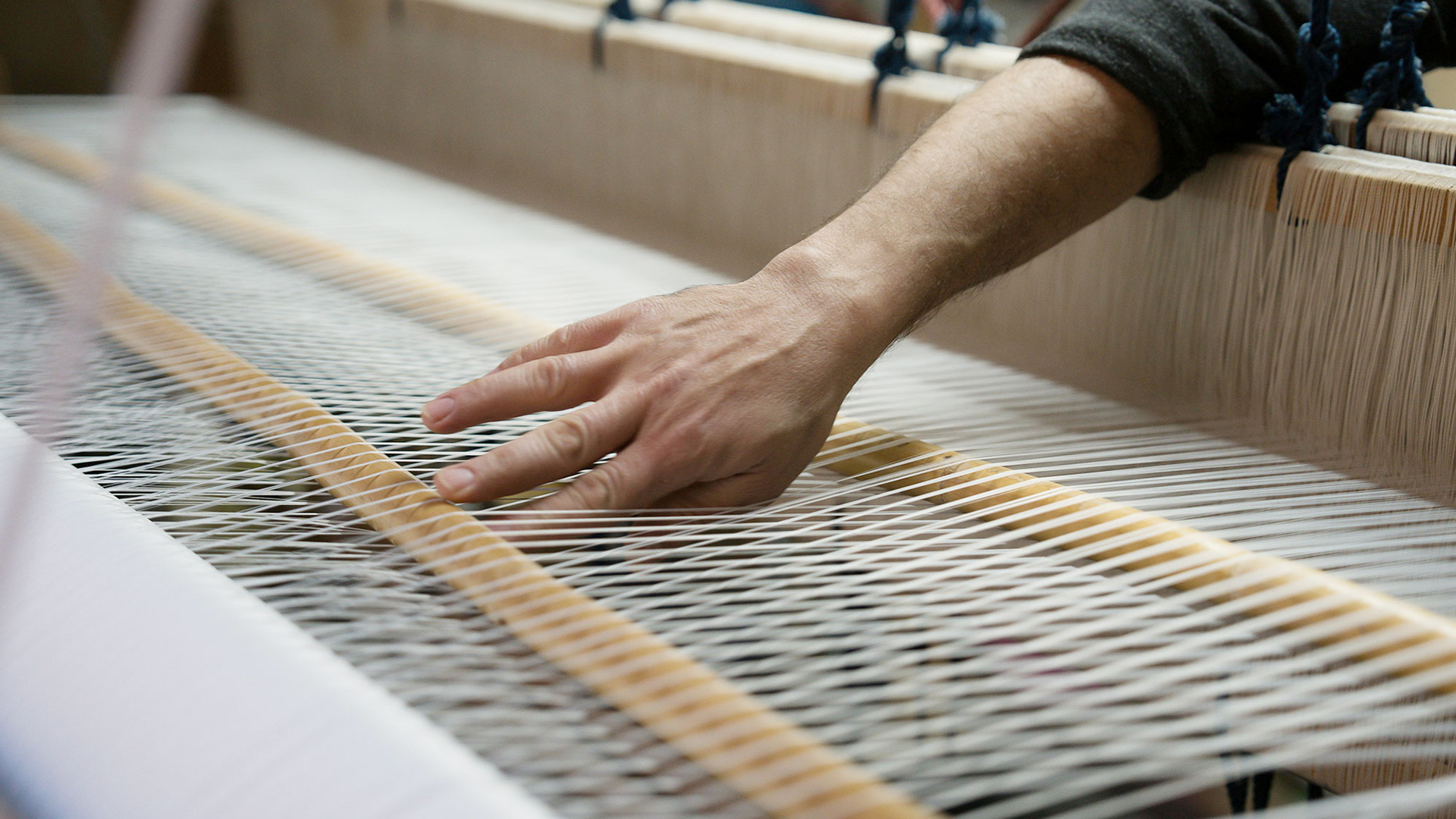 Hand betätigt eine Webmaschine