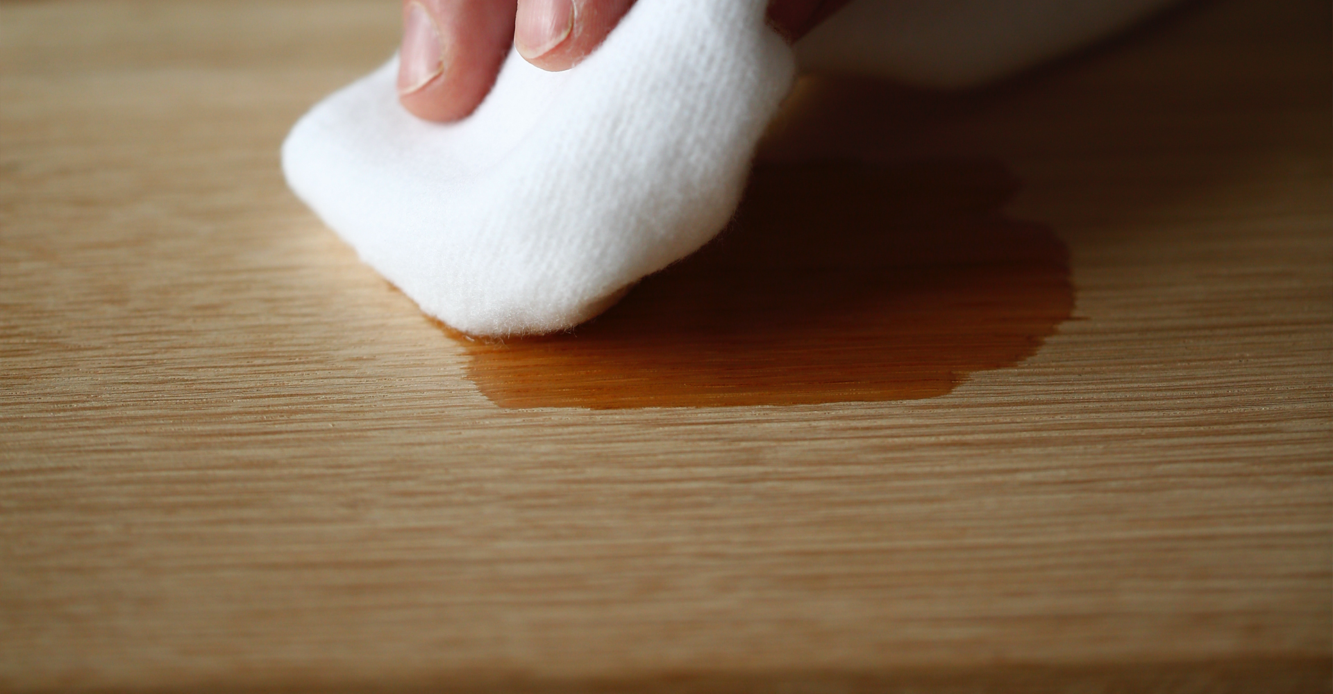 Hand streicht über Holzplatte