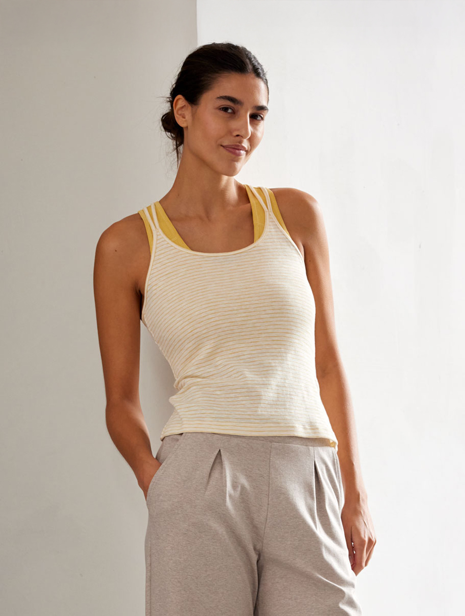 Frau trägt naturfarbenes Top und beige Yogahose