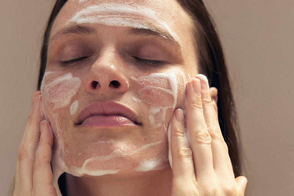 Frau reinigt Gesicht mit Waschschaum