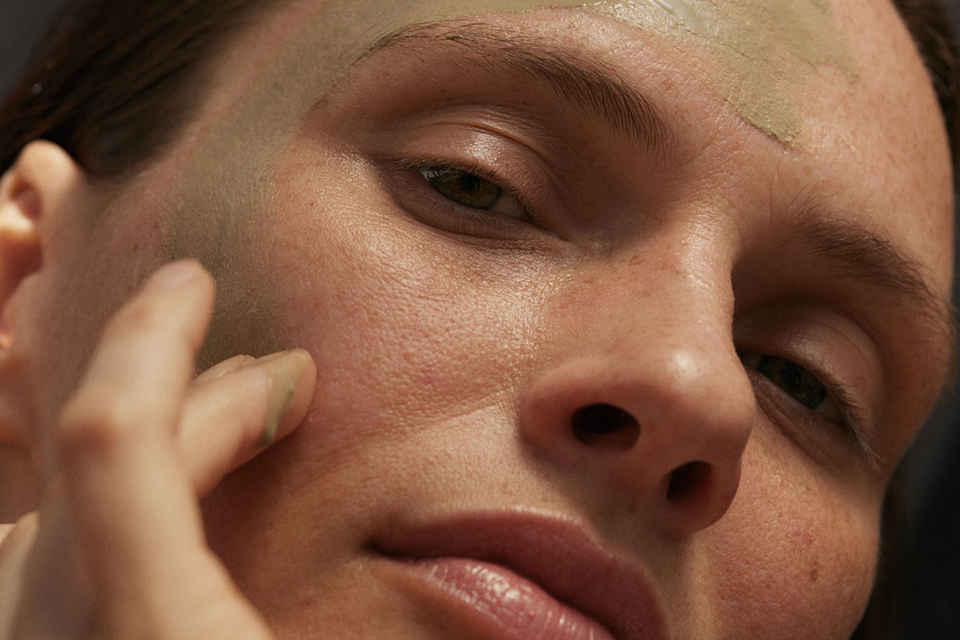 Nahaufnahme einer Frau mit einer grünen Maske im Gesicht