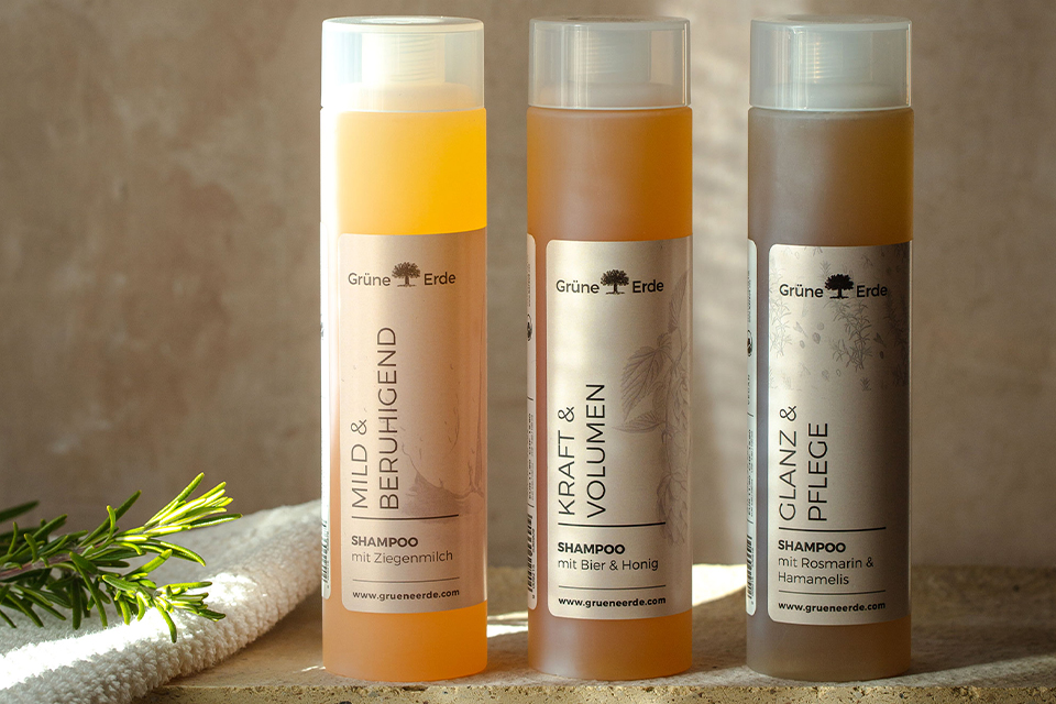 Drei Haarshampooflaschen stehen aufgereiht nebeneinander