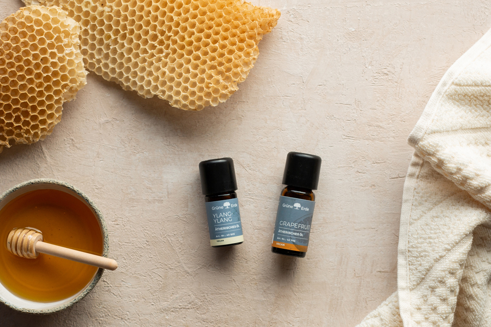 Ätherische Öle neben Honig und Wachs arrangiert