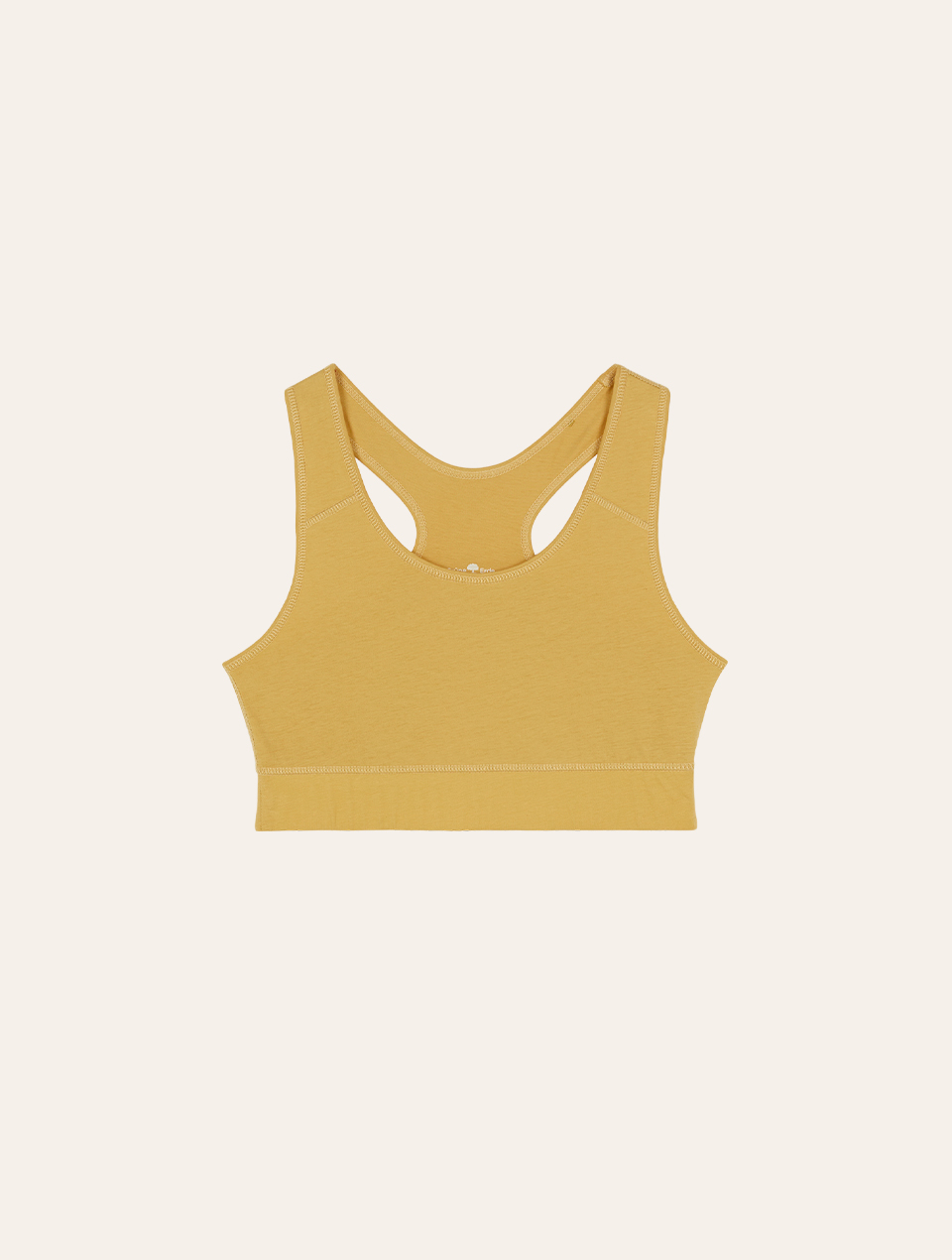 Gelber Yoga Bra vor weißem Hintergrund