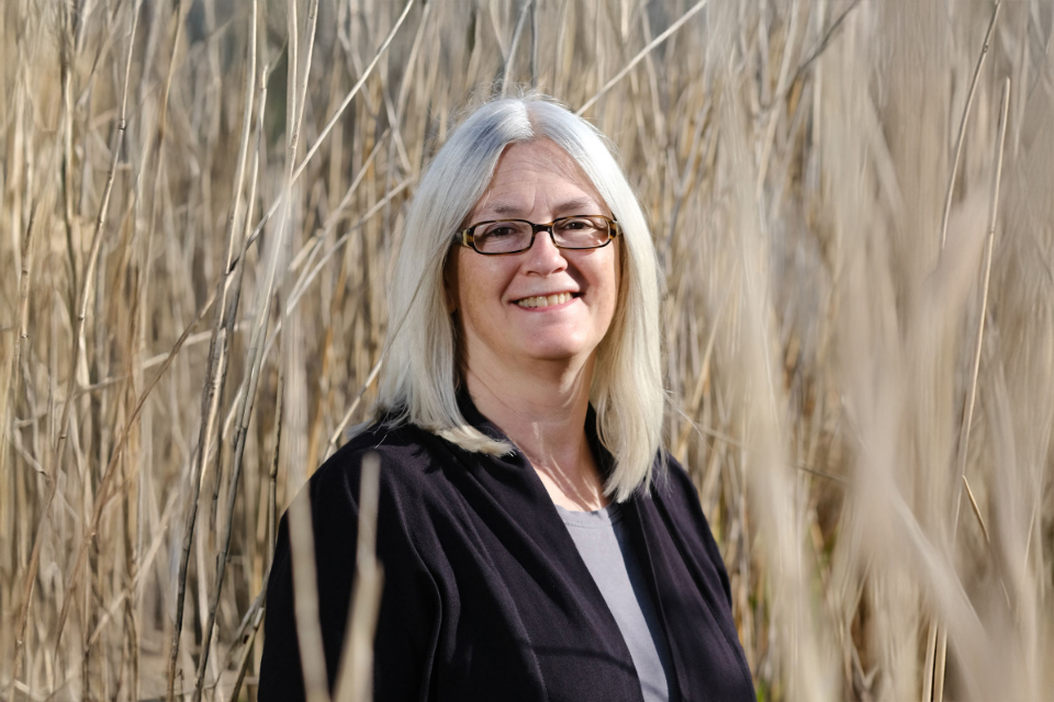 Lächelnde Frau steht im Schilf