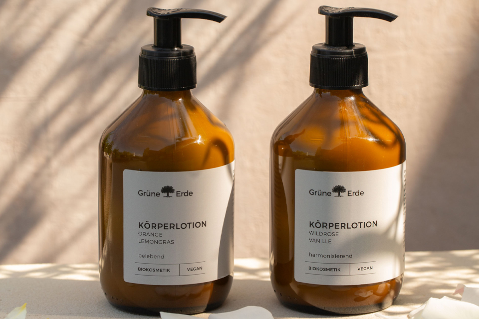 Zwei Körperlotionen in Glasflaschen mit Plastikspendern