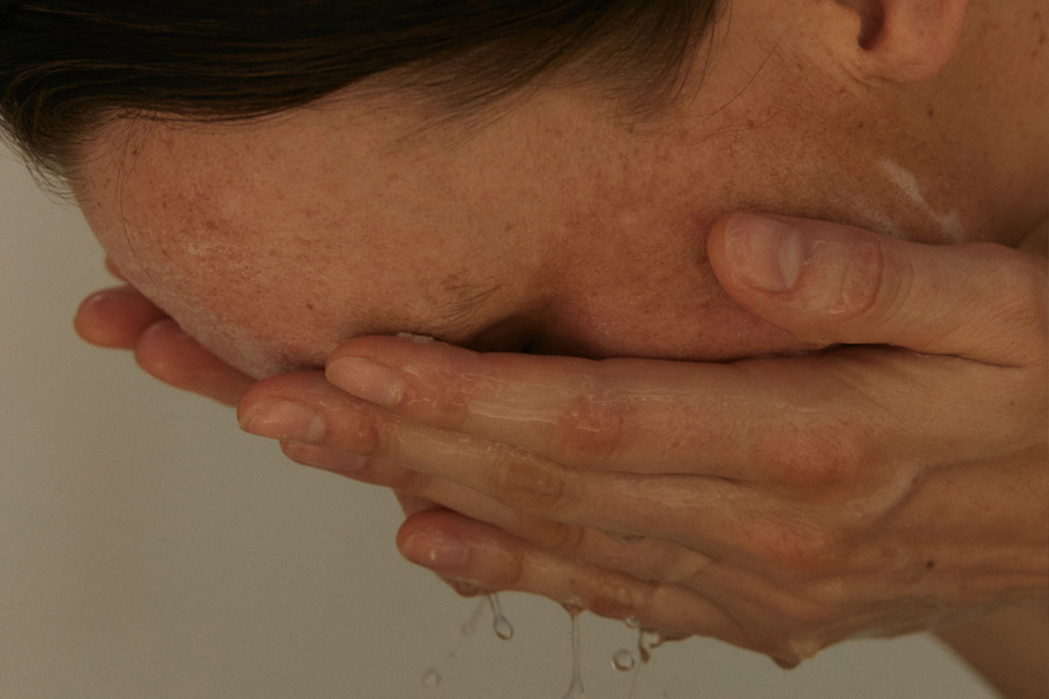 Frau wäscht sich ihr Gesicht