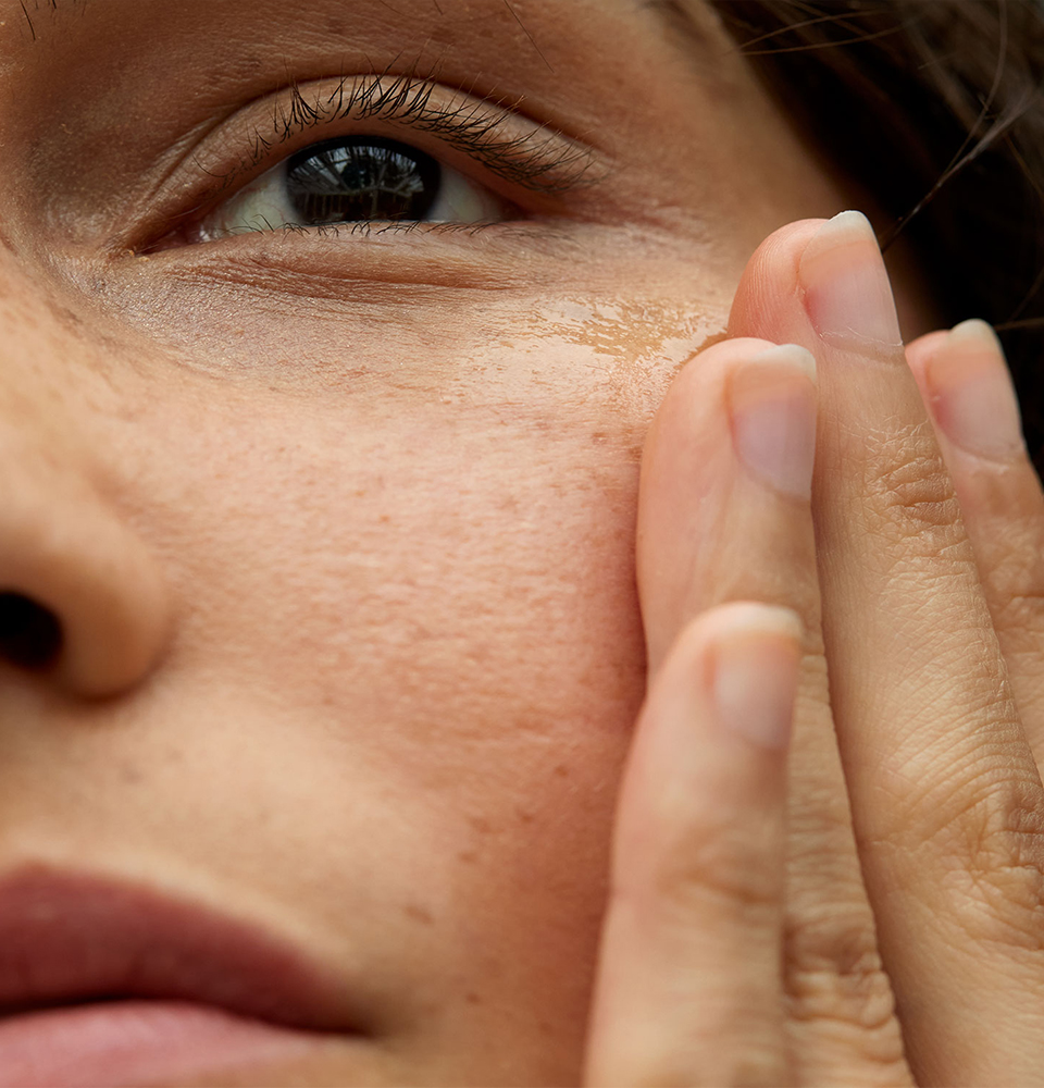 Linke Hälfte eines Frauengesichtes mit einer Hand an der Wange