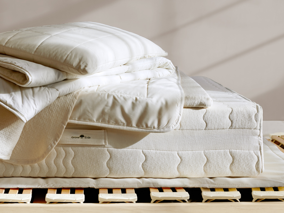 Verschiedene ökologische Schlafprodukte liegen auf einem Lattenrost