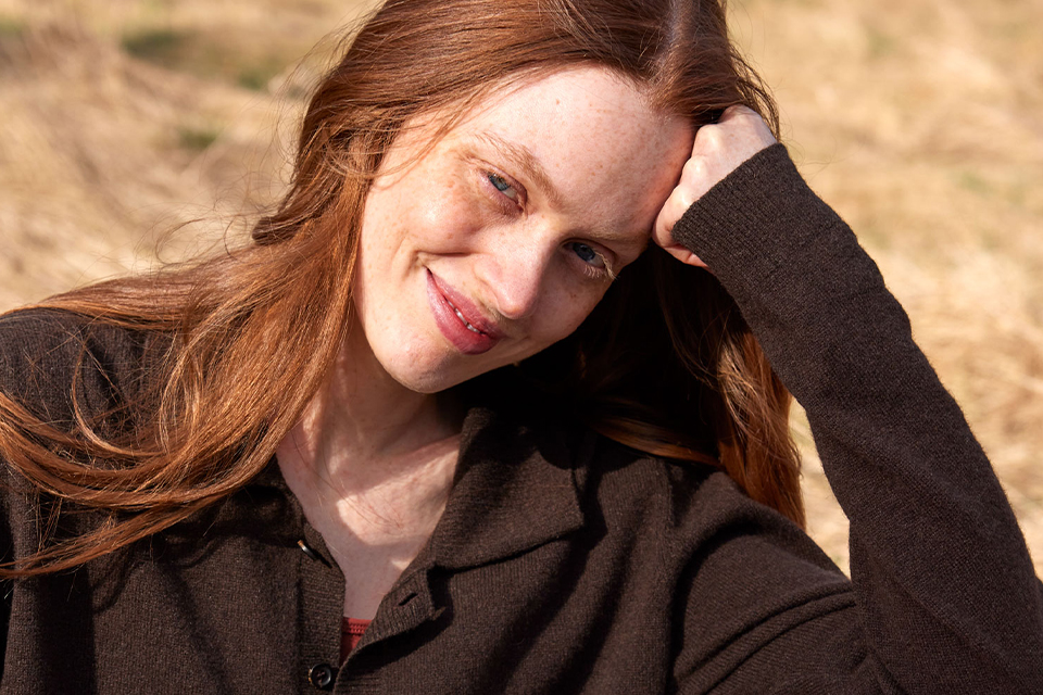 Nahaufnahme einer Frau mit braunem Sweatshirt im Sonnenlicht