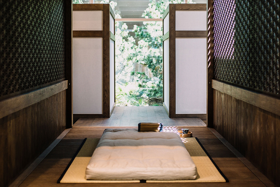 Ruhiger Raum mit Matratze und Blick in naturverbundene Umgebung