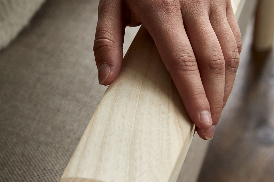 Hand streicht über Holzarmlehne
