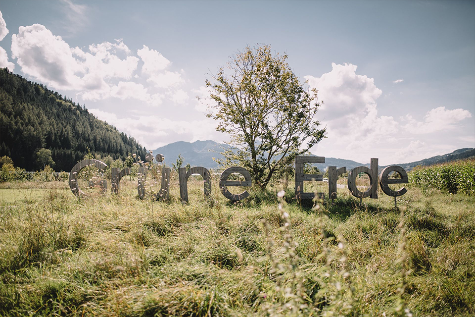 Fünf lachende Kundenberaterinnen vor einer grauen Wand