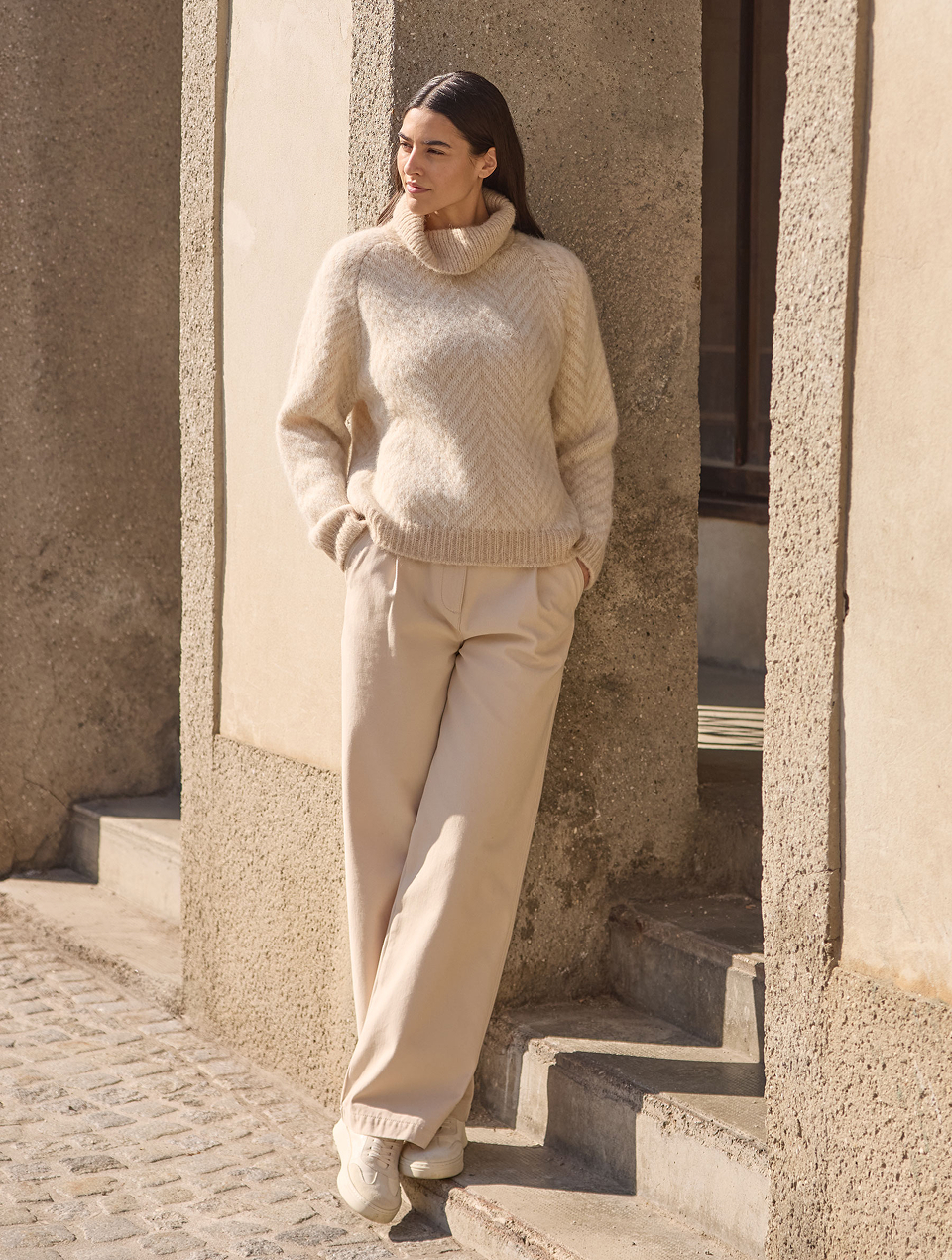 Frau trägt weißen Pullover und weiße Hose