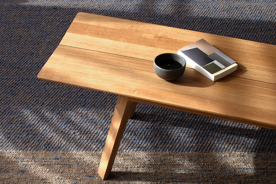 Sitzbank aus Buche auf einem dunkelblauen Naturteppich