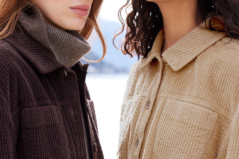 Zwei Personen in warmen Pullovern im Gespräch nebeneinander