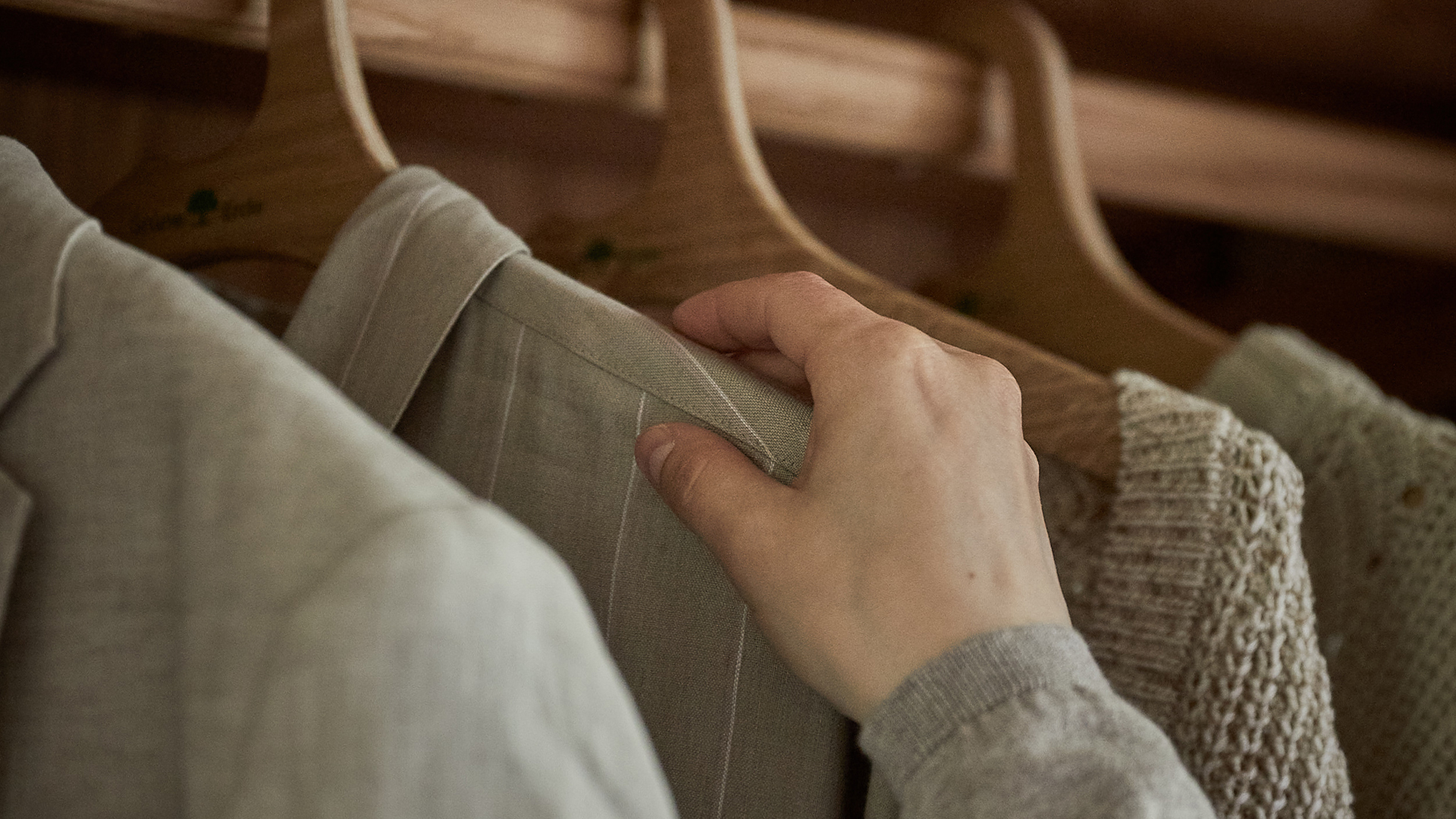 Hand wählt Kleidung aus Kleiderschrank aus