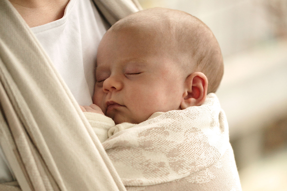 Schlafendes Baby im Tragetuch hängend